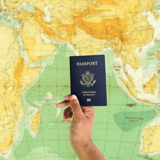 a hand holding a passport over a map